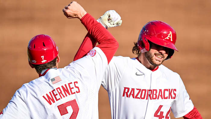 Bobby Wernes and Parker Rowland celebrate a hit in Friday's game at Baum-Walker Stadium.